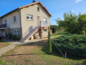 a large house with a staircase in front of it at La Bourzede F3 in Langeac