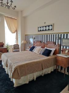 Schlafzimmer mit einem großen Bett mit einem Kopfteil aus Holz in der Unterkunft Locadiera Pansion in Ermoupoli