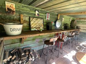 a bar with stools on a wooden wall at Bonshaw Grange-Riverside Country Retreat, & HotTub in Lockerbie