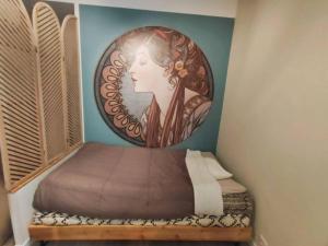 ein Schlafzimmer mit einem Bett mit einem Bild einer Frau in der Unterkunft «l’Orient Express» joli 2 pièces fonctionnel in Nizza