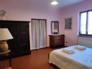 ein Schlafzimmer mit einem Bett, einer Kommode und einem Fenster in der Unterkunft Appartamento Villa Marta in Spoleto