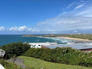 a view of a beach with a building and the ocean at Newquay Fistral Beach View in Newquay