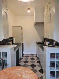 uma cozinha com armários brancos e um piso xadrez em Cozy Studio With Franklin Village View - 30 Day Minimum Stay em Los Angeles