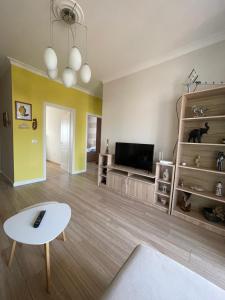 ein Wohnzimmer mit einem Tisch und einem TV in der Unterkunft Sunny Apartment near Castle in Elbasan