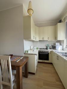 cocina con armarios blancos y mesa de madera en Sunny Apartment near Castle en Elbasan