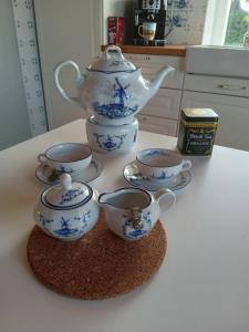 un grupo de tazas de té y una tetera en un mostrador en ehemaliges Müllerhaus, en Schortens