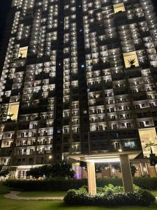 Celandine Residence by DMCI في مانيلا: مبنى شقة كبير في الليل مع شرفة في الأمام
