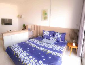 a bedroom with a blue bed with blue sheets and a table at Lakeview apartment - 5 minutes to Westlake - 20' to Noi bai airport in Hanoi