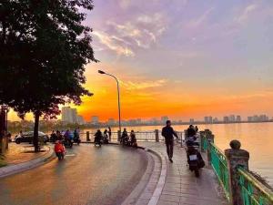 a group of people walking down a street at sunset at Lakeview apartment - 5 minutes to Westlake - 20' to Noi bai airport in Hanoi