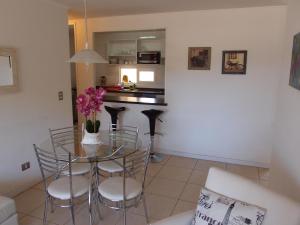 a living room with a table and chairs and a kitchen at Acogedor Departamento en tranquilo balneario, Papudo in Papudo +13 photos