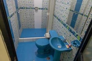 a bathroom with a blue toilet and a sink at La Torre Valsai in Puerto Maldonado