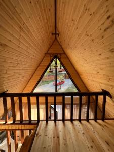 Zimmer mit einem großen Fenster in einer Holzdecke in der Unterkunft Agaruka Cabin Racha in Ambrolauri
