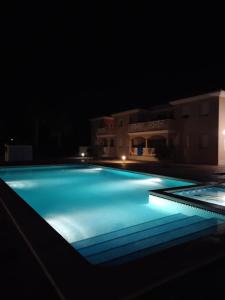 una gran piscina iluminada por la noche en Apartamento en la playa de Riumar, en Riumar