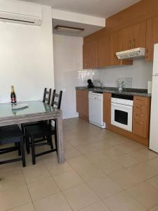 uma cozinha com uma mesa, um fogão e um frigorífico em Apartamento en la playa de Riumar em Riumar