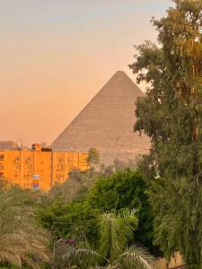 einen Blick auf die Pyramiden von Giza bei Sonnenuntergang in der Unterkunft Royal Pyramids Museum Guest House in Kairo