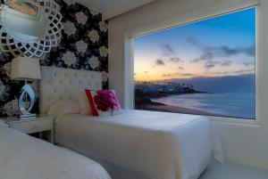 1 dormitorio con cama blanca y ventana grande en Lani's Suites de Luxe - Adults Only en Puerto del Carmen