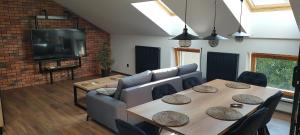 a living room with a table and a couch and a television at Apartamenty Comfort in Gniezno