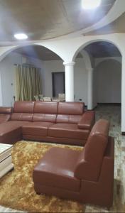 un soggiorno con divano in pelle marrone e tavolo di Victorus Homes a Freetown