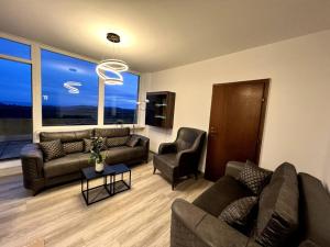 een woonkamer met banken en stoelen en een groot raam bij Penthouse Brockenblick 381 in Braunlage