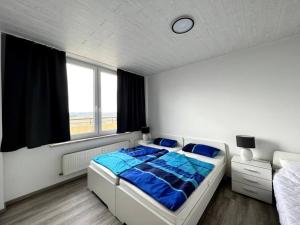 een slaapkamer met een bed met blauwe lakens en een raam bij Penthouse Brockenblick 381 in Braunlage +91 foto's