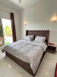 - un grand lit dans une chambre avec une grande fenêtre dans l'établissement Royal view Villa استراحة الشرفة الملكية, à Sayq