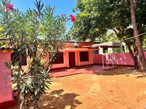 an orange house with a tree in front of it at Jaffna Town in Jaffna