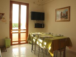 a dining room with a table with chairs and a window at La casetta di Torre dell'Orso in Torre dell'Orso