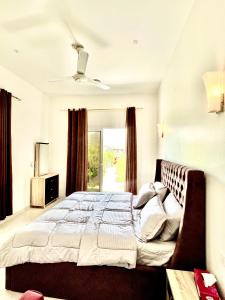 Un dormitorio con una cama grande y una ventana en Royal view Villa استراحة الشرفة الملكية, en Sayq