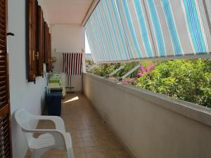 a balcony with a white chair and some plants at La casetta di Torre dell'Orso in Torre dell'Orso