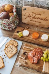 a table topped with different types of bread on cutting boards at Chão do Ribeirinho 