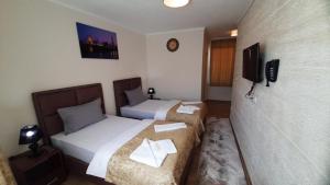 a hotel room with two beds and a television at Prenoćište-Sobe My Place in Novi Pazar