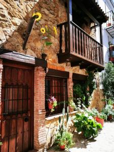 IznatorafにあるCasa Rural Los Girasolesの木製のドアとバルコニー付きの石造りの建物