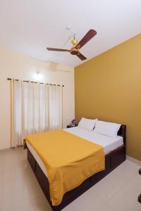 a bedroom with a bed with a ceiling fan at SKY BLUE HOMESTAY with POOL in Vythiri