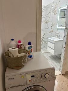 a washing machine with a basket on top of it in a bathroom at Victorias apartment Tirane in Tirana
