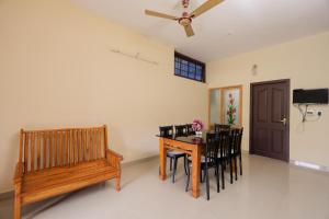 a dining room with a table and chairs and a bench at SKY BLUE HOMESTAY with POOL in Vythiri