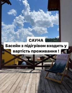 een stoel op een terras met uitzicht op de lucht bij VULYK z MEDOM in Boekovel