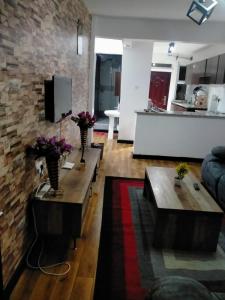 a living room with two tables and a stone wall at Two Bedrooms Furnished Apartment in Nakuru in Nakuru
