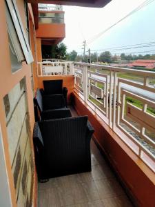 2 sillas en el balcón de un edificio con ventanas en Two Bedrooms Furnished Apartment in Nakuru en Nakuru