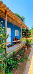 una casa azul con un banco bajo un techo en Rancho Acácia São Roque, en São Roque