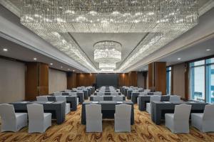 a conference room with a large chandelier and tables and chairs at Sheraton Shanghai Pudong Riverside in Shanghai +60 photos
