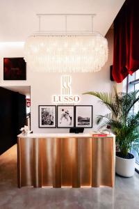 a lobby with a reception desk and a chandelier at Lusso Hometels J One Business Bay in Dubai
