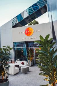 Lusso Hometels J One Business Bay في دبي: لوبي مبنى اثاثه ابيض والنباتات
