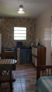 a living room with a table and a kitchen at Chalés Caminho do Mar in São Miguel dos Milagres