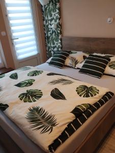 a bed with a comforter with plants on it at Apartament RESET 2 pokojowy in Ustroń