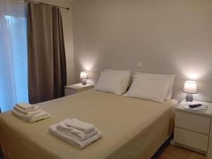 um quarto com uma cama com toalhas em Casa Jasmim em Algueirão