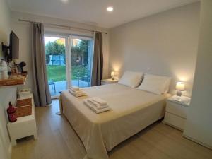 um quarto com uma cama grande e toalhas em Casa Jasmim em Algueirão