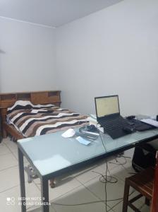 un ordenador portátil sentado en un escritorio junto a una cama en Apartamento Peruvian Black, en Lima