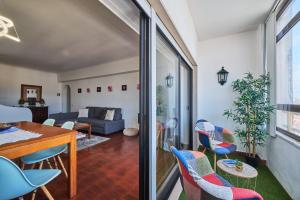 a living room with a table and chairs at Aiyra Beach House in Costa da Caparica