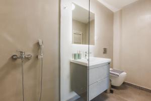 a bathroom with a shower and a sink and a toilet at Lavish condo in Athens Riviera in Athens