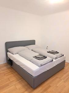 a bed in a room with white walls and wooden floors at Somnium - Appartements Südsteiermark - Stammhaus in Weitersfeld an der Mur